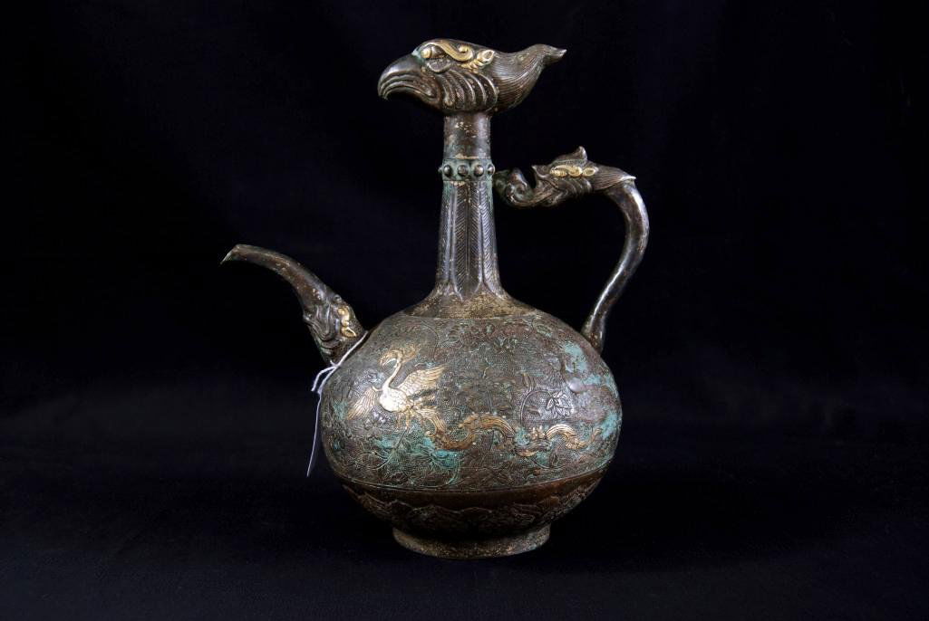 A RARE CHINESE "PHOENIX HEAD" SILVER EWER: Rises to a tall tapering neck decorated with surmounted in the form long sinuous tail feathers flanked of a phoenix head, the bottle body centering blossoming form foliate vines on a fine ring punched