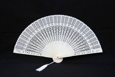 A CHINESE IVORY FOLDING FAN: Chinese ivory reticulated fan with tassel. Length: 14 1/2in (37cm).