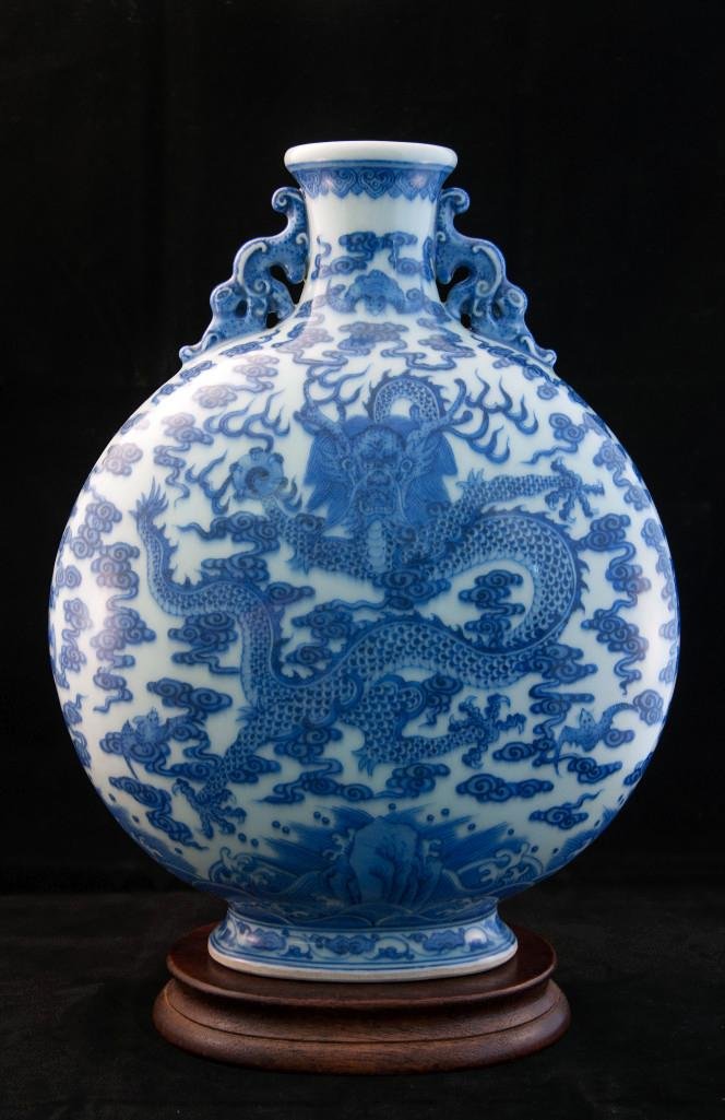 A BLUE AND WHITE PORCELAIN MOONFLASK: Underglaze blue decoration of dragons and clouds, six-character Chi'ien Lung mark on the base. Height: 12 5/8in (32cm). 