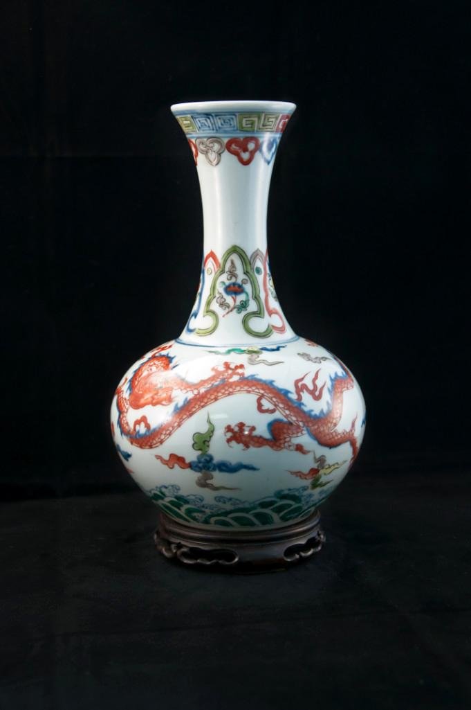 A DOUCAI DRAGON BOTTLE VASE: Finely painted on the exterior with two iron red and green five-clawed striding dragons interspersed with multi-coloured clouds above rockwork and breaking waves, six-character Xunde mark, Height: 9 3