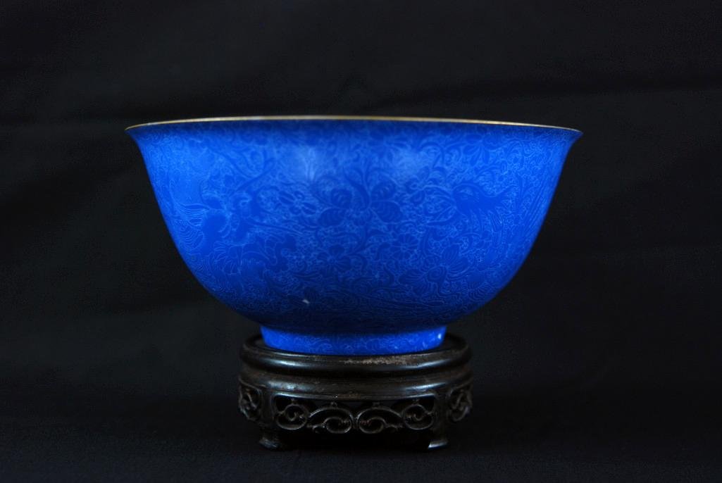 A BLUE CORAL-GROUND PORCELAIN OF DRAGON AND PHOENI: A deep ground bowl decorated with flaring tails of phoenix and dragon chasing a lotus flower, four-character mark on base. Height: 2 5/8in (6.5cm), Diameter: 5 5/8in (14.5cm).