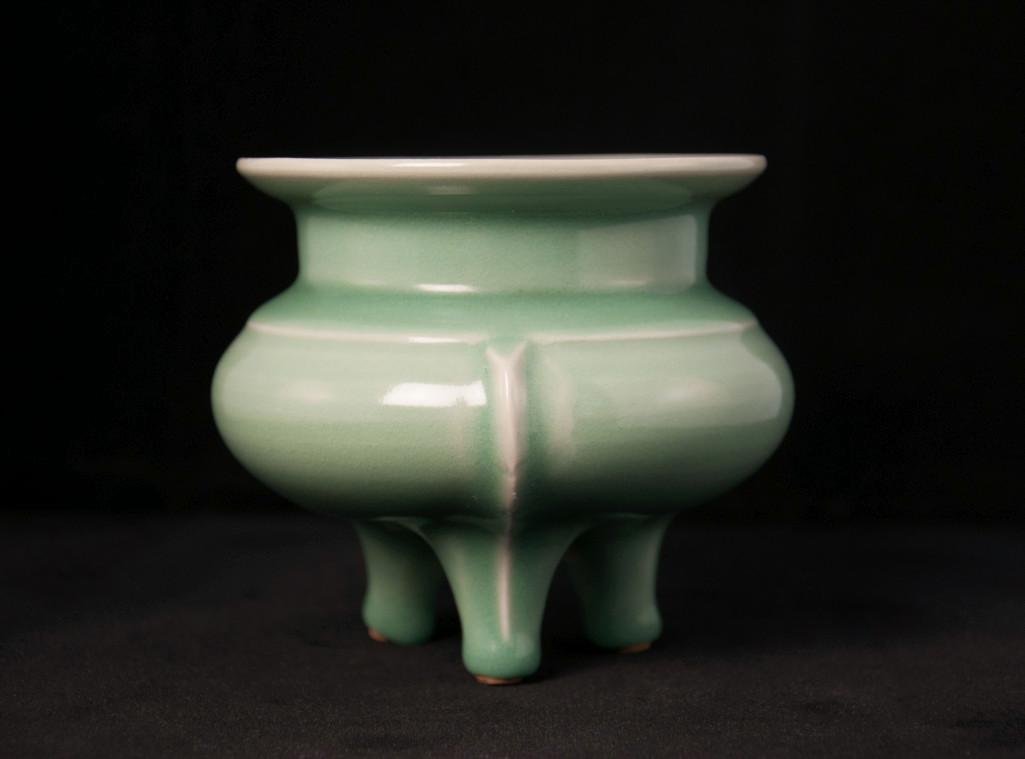 A LONGQUAN CELADON TRIPOD CENSER: A raised rib at the shoulder with the compressed globular body moulded, straight neck supporting a flattened everted mouth rim, connected to three raised lines running vertically from the shoulder to 