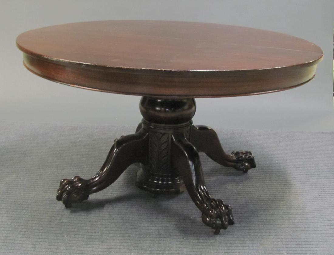 Large Dining Table on Pediment Base, 20th c.: A large mahogany dining table on pediment base, 20th century. To include four leaves. Rounded extendable top on a carved vase shaped pediment, resting on splayed legs with ball and claw feet, terminat