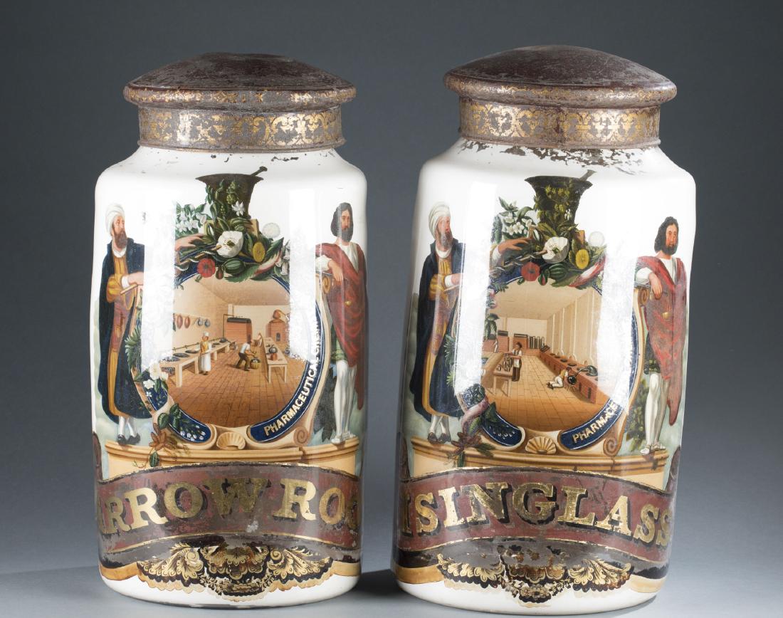 Pair of Reverse-Painted Apothecary Jars, 19th c.: A large pair of reverse-painted glass apothecary jars with tin painted lids, mid-to-late 19th century. Probably English. "Isinglass" & "Arrow Root" jars from "Pharmaceutical Chemist." 24 1/2" h x 12" 