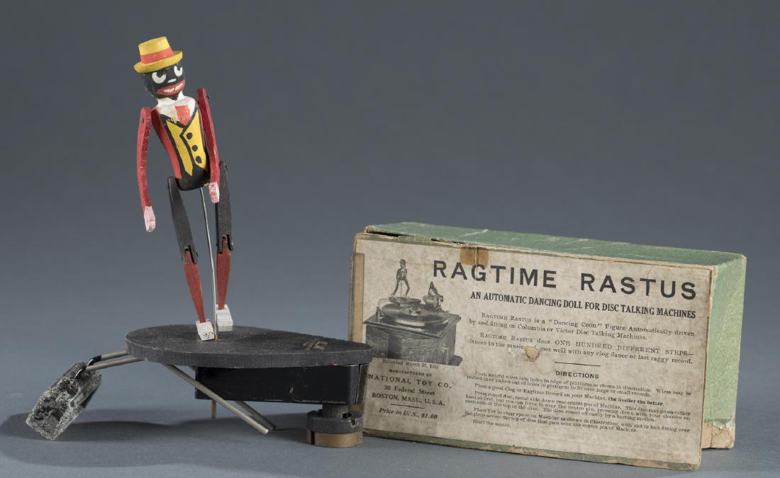 National Toy Co. "Ragtime Rastus" Dancing Toy.: A National Toy Co. "Ragtime Rastus" polychrome painted & carved dancing doll for disc talking machines. Automatically driven by & fitting on Columbia or Victor Disc Talking Machines. To include origin