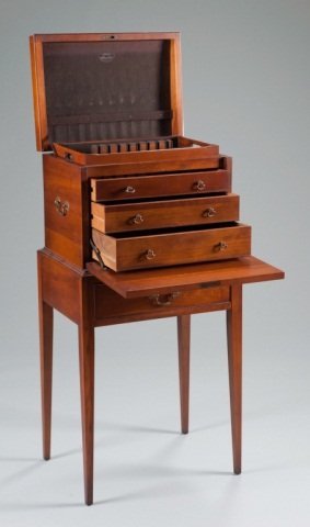 A Mahogany Silver Chest on Stand: A Mahogany Silver Chest on Stand. With molded edge to the lift top, string inlay to the fall front, brass double handles. On a fixed stand with single cockbead molded drawer and square tapered legs. 4