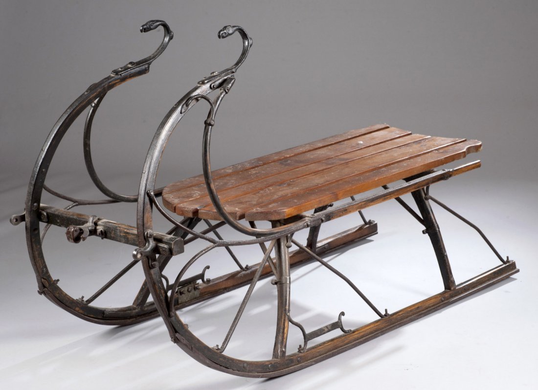 Wood and Iron Sled, 19th Century: Wood and Iron Sled, 19th Century Frame painted black, with six plank seated base. Tops of iron rails are figural bird heads. Refinished seat. 33"" x 51"" x 20""