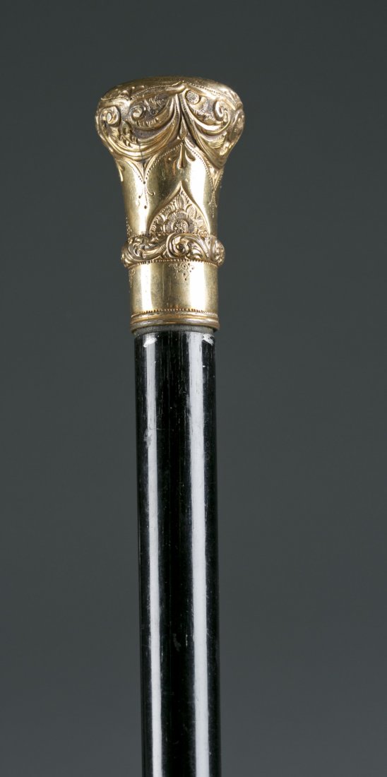 Walking Cane with Gold Handle: Walking Cane with Gold Handle Dark finished wooden walking stick cane with ornate gold plate top with inscription reading ""F.A. Gaffney, O.P."" and dated April 12, 1889. Bottom tip missing. 35"" L