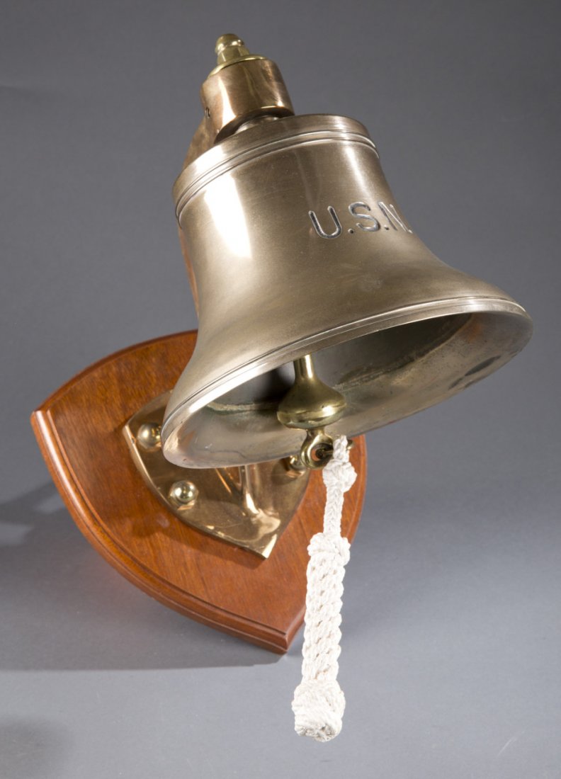 U.S. Navy Brass Ship's Bell: U.S. Navy Brass Ship's Bell Brass ship bell engraved with ""U.S.N."". Placed on wooden plaque. Intact bell rope. 15"" H x 9 3/4"" Dia, plaque 10 1/2"" H x 10"" W