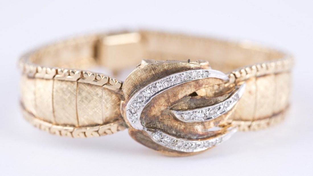 Ladies "Geneva" 17 Jewel Yellow Gold and Diamond Watch: Ladies ""Geneva"" 17 Jewel Yellow Gold and Diamond Watch Mother-of-pearl face and floral cover with approx. .25ct of rose cut diamonds. Marked ""14Kt"" on the back of the case and on the clasp of the 