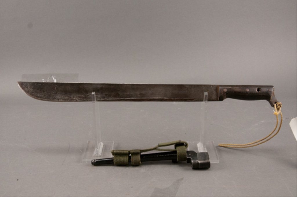 1942 Machete and British Enfield Spike Bayonet: US marked 1942 plumb machete. Grip is broken. Blade is brown. British Enfield spike bayonet and scabbard. Shows wear and has import mark.
