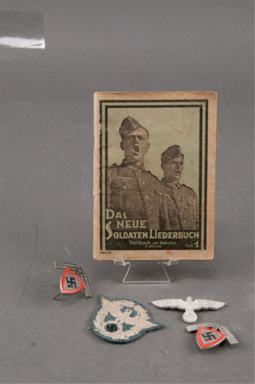 Group of German WWII Items: To include: Two(2) RAD cap badges, Army visor cap badge, police army patch and soldier's song book. Book shows wear and stains. Patch shows signs of use and is dirty.