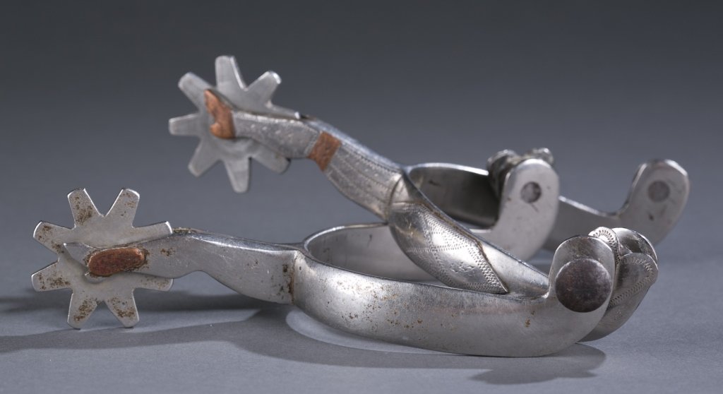 Pair of Handmade White Metal Spurs: Bright engravings. Figural spur support is a woman's leg with copper accents. Heart buttons on one side of each spur. 6" L