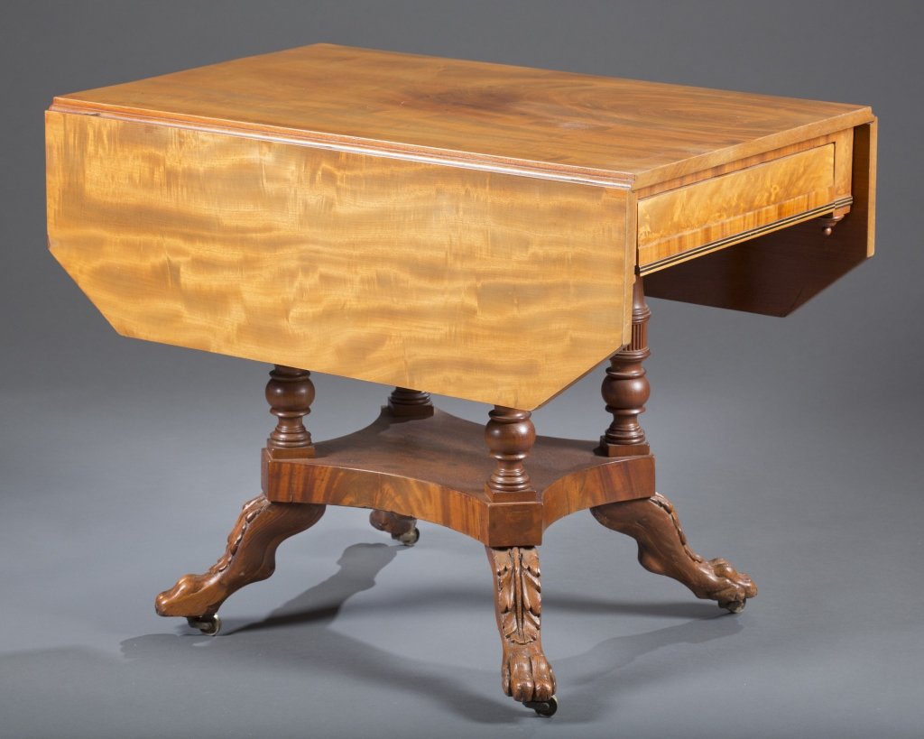 Ca. 1840 American Empire Drop Leaf Table: New York or Philadelphia Mahogany with flame mahogany veneers Single drawer Architectural carved supports, paw feet resting on casters. 28 1/2" H x 46" L x 36" W