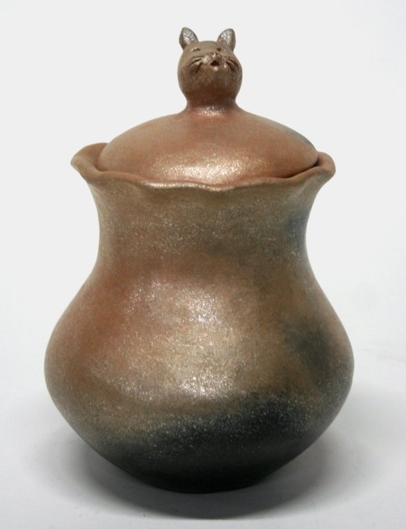 Anthony Durand Micaceous Slip Cat Pottery Jar.: Picuris Pueblo, New Mexico. 3rd quarter 20th c. Tan and black body with micaceous luster over-glaze and scalloped mouth. Lidded clay jar with cat head finial. On bottom, incised with artist signature