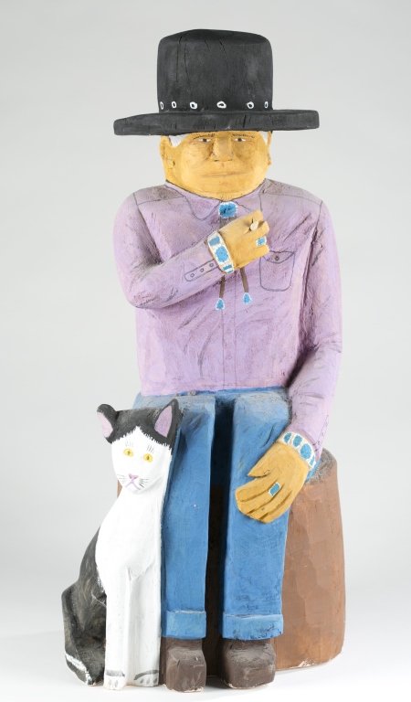 Johnson Antonio (US/Navajo Nation, b. 1931).: Native American man smoking and sitting next to a cat, c. 1993. Carved and painted wood. Signed and dated on base. 25 1/4"h x 9 1/2"l x 12"w. Featured in, "Trading Post Guidebook: Where to find the Tr