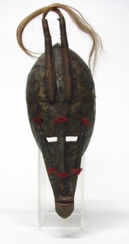 African Wood & Metal Mask.: Probably Malinke people, Mali. Carved wood with chased designed metal overlay, red thread accents, and animal hair. 15"h x 6"w x 4"d.