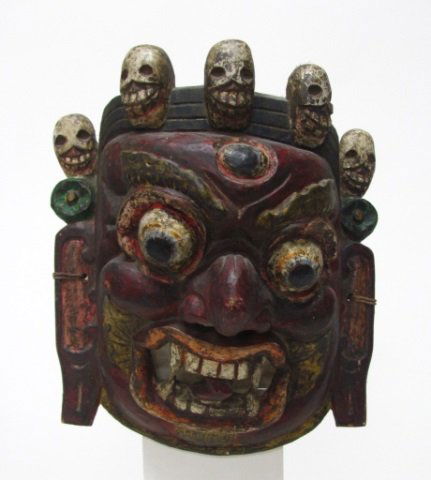Polychrome Balinese Demon Dance Mask.: Polychrome carved wood of a demon with a third eye and decorated with a band of skulls. On inside, impressed partial red wax seal. 12 1/2"h x 10 3/4"w x 4 3/4"d.