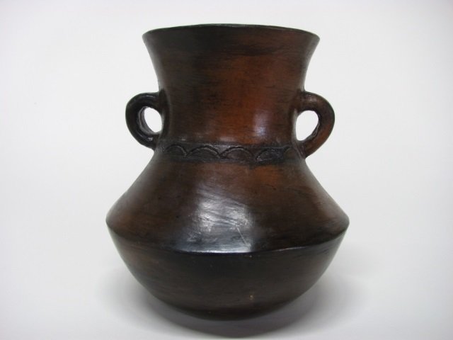 Rose Williams (US/Navajo Nation, 1915-2015).: Brown and black two-handled vase. Half-moon decoration encircling neck. Initials incised on bottom. 8 3/4" h. Featured in, "Trading Post Guidebook: Where to find the Trading Posts, Galleries, Auctions