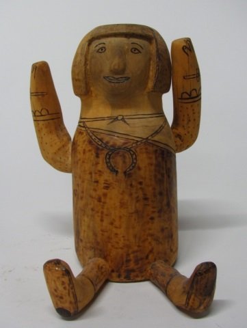 Guadalupe Ortiz (Cochiti Pueblo, NM., 20th c.).: Carved wood sitting figure with upraised arms. Incised design detail colored black. On bottom, G. Ortiz with a feather.