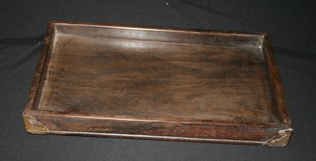 A Chinese Zitan Scholar's Tray: raised on a low beaded trim, with Ruyi-shaped metal mounts Width 34.5 cm Depth 21 cm Height 3.5 cm Collection of a South Sydney Gentleman