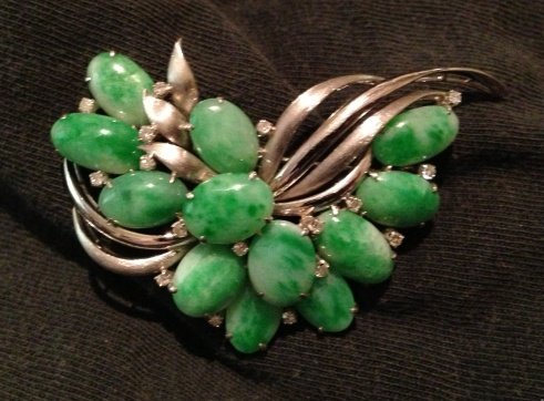 A Chinese 18 Carat White Gold ,Jade and Diamond Brooch: modelled in freeform, set with a seletion of jade cabochons and diamond chips , l 6.5cm w 15 grams