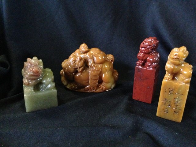 A Selection of Chinese Soapstone Chops,: each modelled with kylins , w 7cm (4)