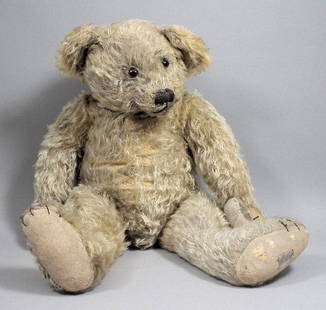 A 1920s Farnell teddy bear in old gold mohair, wit: A 1920s Farnell teddy bear in old gold mohair, with glass eyes, stitched nose, and felt pads, 24ins high (with Farnell's Alpha Toys stitched label to foot (pads to paws replaced, worn and mothed to