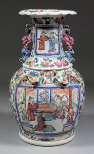 A Chinese porcelain bulbous two-handled vase moulded in: A Chinese porcelain bulbous two-handled vase moulded in relief with dragons and kylin pattern handles and enamelled in colours in the "Cantonese" manner with figures on a terrace within borders decora
