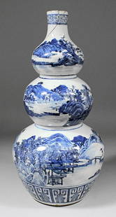 A Chinese blue and white porcelain triple gourd shaped : A Chinese blue and white porcelain triple gourd shaped vase painted with figures in a river landscape, 17.75ins (451mm) high (late 19th/early 20th Century - cracked and repaired at neck)