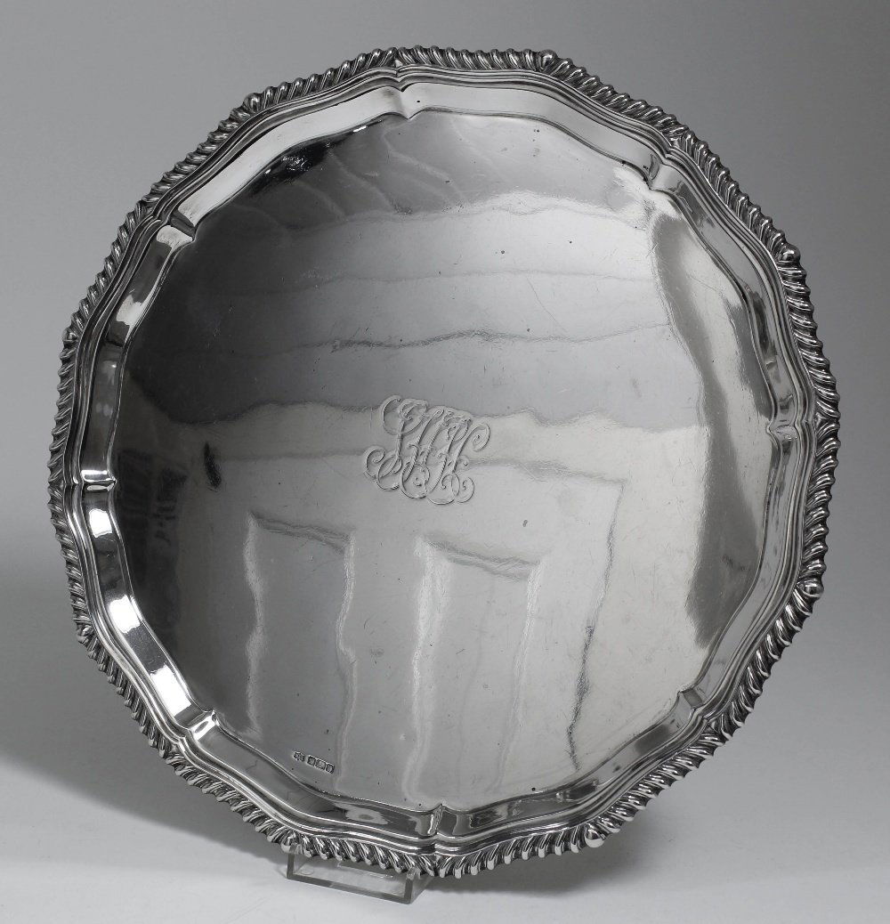 A George V silver circular salver, the shaped and mould: A George V silver circular salver, the shaped and moulded rim with gadroon mounts and engraved to centre with initials, 12.25ins diameter, by Mappin & Webb, Sheffield 1912 (weight 25ozs)