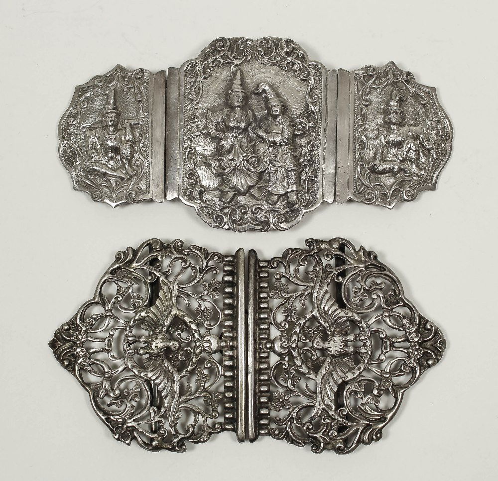 A late Victorian “Nurse’s silver buckle cast with a bir: A late Victorian “Nurse’s silver buckle cast with a bird with out-stretched wings, floral and leaf scroll ornament, 5ins x 2.75ins, by Charles Stuart Harris, London 1893, and a Siamese silver buck