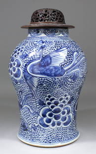 A Chinese blue and white porcelain baluster shaped vase: A Chinese blue and white porcelain baluster shaped vase in the Kangxi manner, painted with exotic birds and flowers, 14ins (356mm) high, and pierced and carved wood cover for same (early 20th Century)