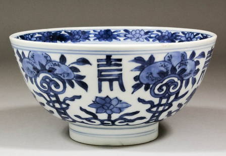 A Chinese blue and white porcelain bowl painted with pe: A Chinese blue and white porcelain bowl painted with peaches, scrollwork and Chinese characters, 7ins (178mm) diameter x 3.5ins (89mm) high (apocryphal six-character mark - mid 17th Century - two