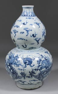 A Chinese blue and white porcelain double gourd shaped : A Chinese blue and white porcelain double gourd shaped vase painted with dragons, 14ins (355mm) high (20th Century)