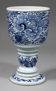 A Chinese blue and white porcelain goblet with bulbous : A Chinese blue and white porcelain goblet with bulbous knop to stem, painted with flowers and leaves, 7ins (178mm) high (lacking cover - Kangxi period - bowl restored)