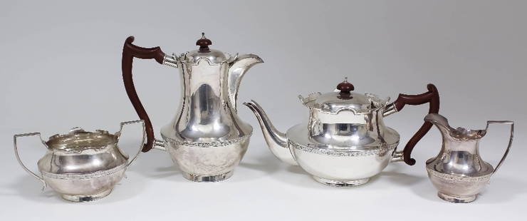 A George V silver four piece tea service, the squat: A George V silver four piece tea service, the squat bulbous bodies with shaped rims, comprising - teapot, hot water jug, two-handled sugar basin and milk jug, by Wilmot Manufacturing Co, Birmingham