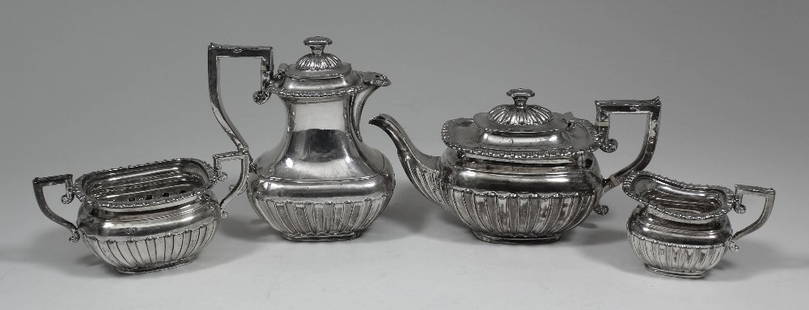 An Edward VII and George V silver rectangular four: An Edward VII and George V silver rectangular four piece tea service with reeded and fluted mounts and body and leaf capped angular handles, comprising - teapot, hot water pot, sugar basin and milk