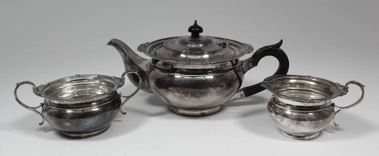 A George V silver circular three piece tea service with: A George V silver circular three piece tea service with reeded and shell mounts and scroll handles, comprising - teapot, sugar basin, milk jug, by Carrington & Co, London 1917 (gross weight 36ozs)