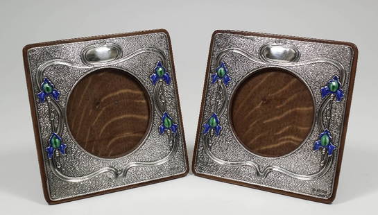 A pair of Edward VII silver and enamelled square: A pair of Edward VII silver and enamelled square photograph frames of Art Nouveau design, each 6.5ins square (to hold pictures 3.5ins diameter), by Zimmerman, Birmingham 1903/4 (with replaced oak