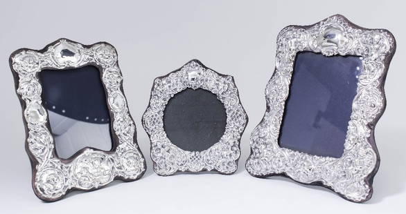 An Elizabeth II silver photograph frame of Victorian: An Elizabeth II silver photograph frame of Victorian design embossed throughout with cupids and leaf scrolls, 9.5ins x 7.5ins (to take picture 5.5ins x 4ins), by K.F. Ltd, London 1981, and two