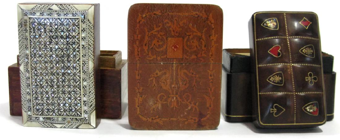 3 VINTAGE PLAYING CARD HOLDERS - INLAY, LEATHER: 3 VINTAGE PLAYING CARD HOLDERS - INLAY, LEATHER: 1.) Wood inlay with a central playing card surrounded by scrolling grotesques and foliate decoration, 4.5"l x 3.375"w x 1.5"h. 2.) Italian leather over