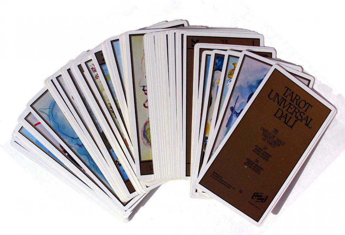 Dali Universal Tarot Card Set: The outer slipcover is covered in burgundy-red velvet with gold lettering, and the inner case containing the cards laminated, dark brown, cardboard, also with gold lettering. The set includes all 78 T