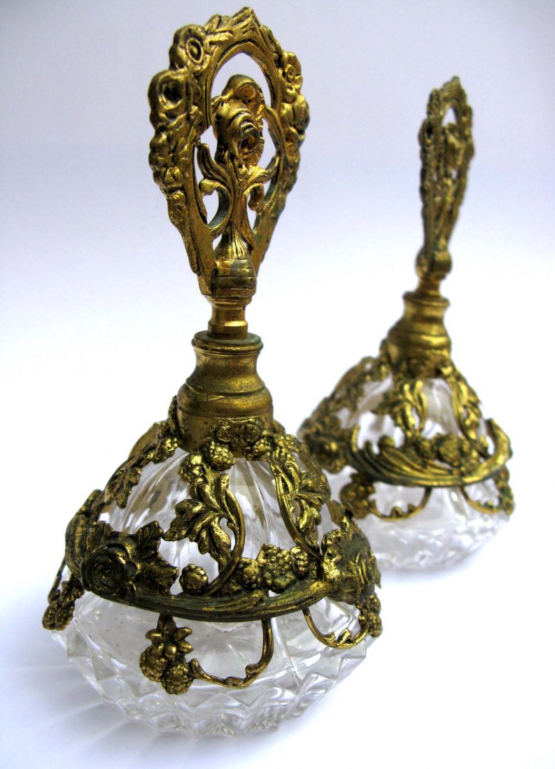 Pair of Vintage Glass and Ormolu Perfume w/Roses: This is a vintage pair of glass and gilded metal mount perfume bottles. The gilded mounts and finials have ornate molded rose garlands throughout. These measure 5.5”h x 2.75”w. No reserve.
