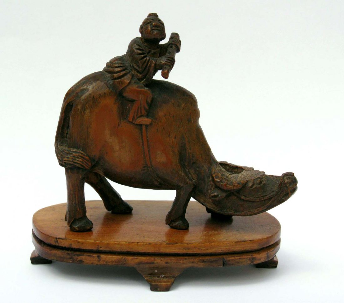 Well Done Chinese Wood Carving of Boy on Buffalo: This is a well carved early 20th century palm wood carving of a boy riding a buffalo. This includes carved wood footed base. Figure measures 3.125”h x 3.5”l x1”d. Hand cut base measures 1.875w x