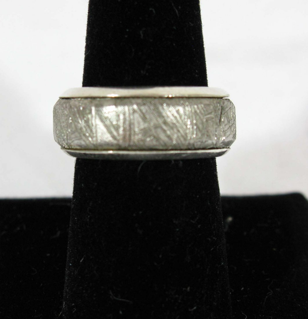 Meteorite and Sterling Silver Ring: Meteorite Men's Ring is housed in a .925 sterling silver mount encompassing a genuine meteorite, the semi-matte finish has been polished to highlight the criss-crossing lines of the Widmanstatten patt