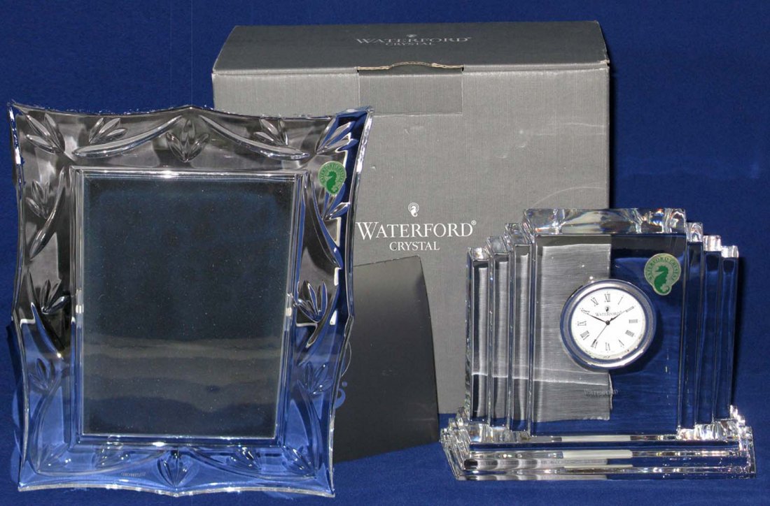 Lot 2 Waterford Crystal Clock & Frame: Lot of 2 Waterford Crystal pieces. Lot 1 of 2: Waterford Metropolitan lead crystal clock; 4.75"h x 6"l. This piece is housed in the original box with the original paperwork. Lot 2 of 2: Waterford lead