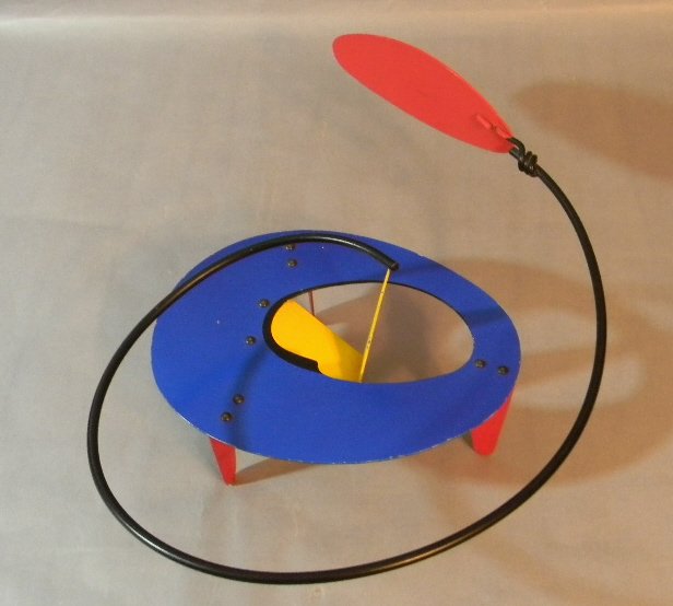 Brad Howe Kinetic Metal Sculpture Calder Style: Brad Howe (1959, America), Kinetic Metal Sculpture in the style of Calder. Three red coated metal legs supporting a blue ovoid platform with yellow slanted point extending up. Upon this point freely b