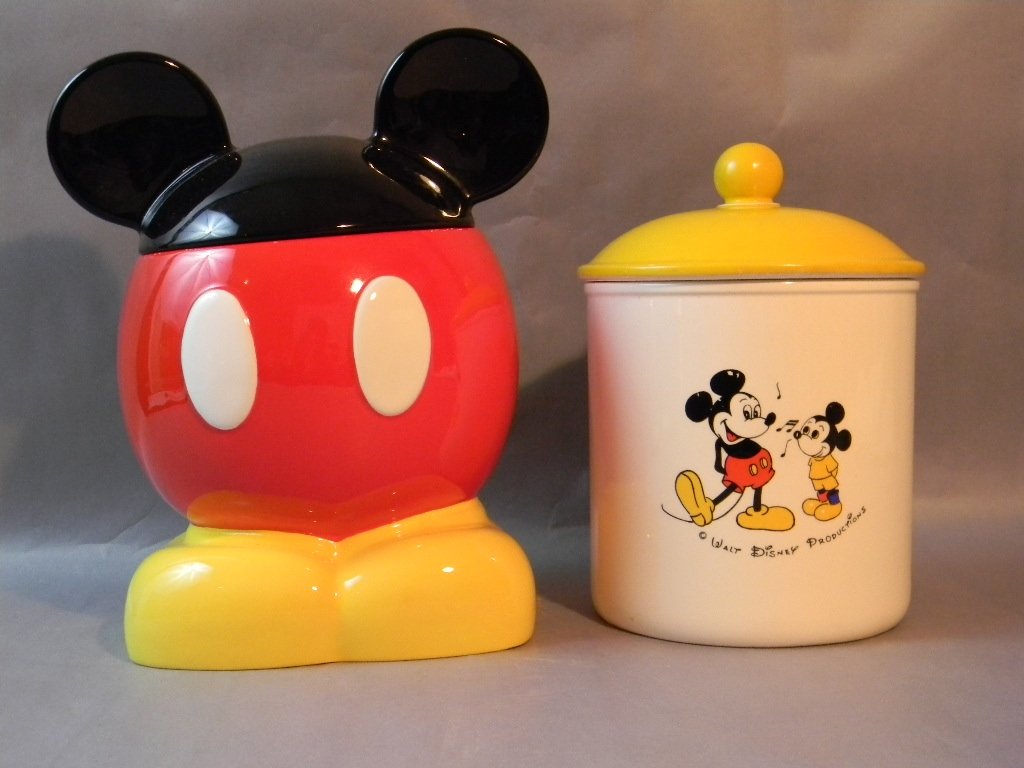 Pair of Mickey Mouse Disney Ceramic Cookie Jars: Pair of Mickey Mouse Disney Ceramic Cookie Jars, lot 1 of 2 vintage Walt Disney Productions" cookie jar with yellow lid, 9"h, light glaze chipping to the lid; Lot 2 of 2 Mickey Mouse Cookie Jar with e
