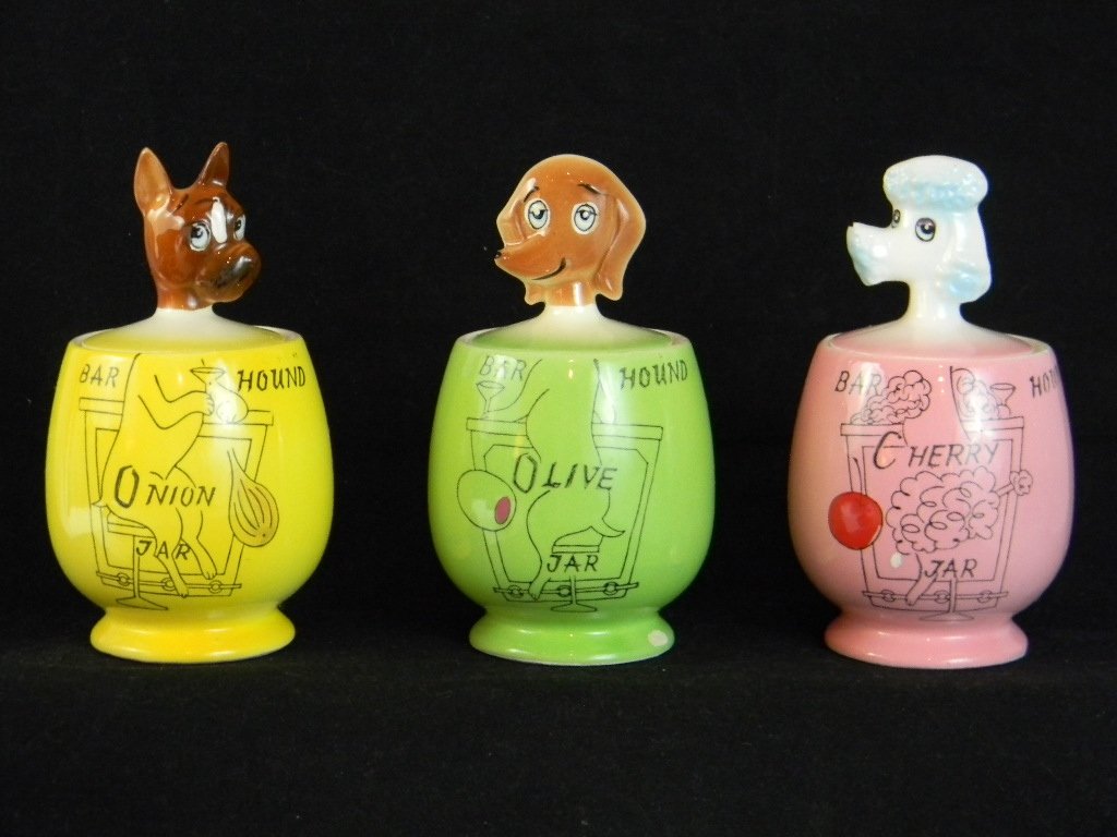 3 MID-CENTURY MODERN BAR HOUND COCKTAIL CONDIMENT: 3 MID-CENTURY MODERN, c. 1950s, BAR HOUND COCKTAIL CONDIMENT HOLDERS, Ceramic holders for Olives, Onions and Cherry with molded handles in the form of a Poodle, Boxer and Daschund